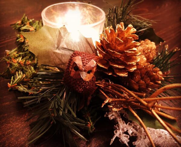 A candle sitting on top of some pine cones.