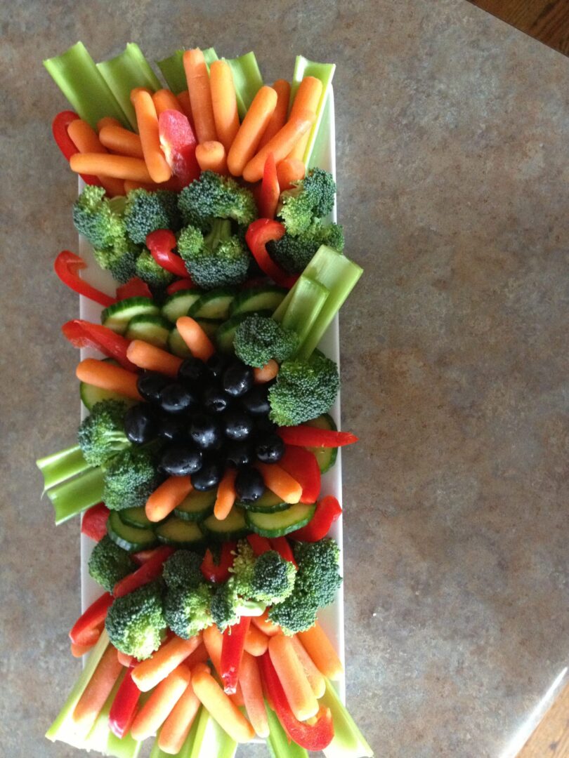 A tray of vegetables is shown with grapes.
