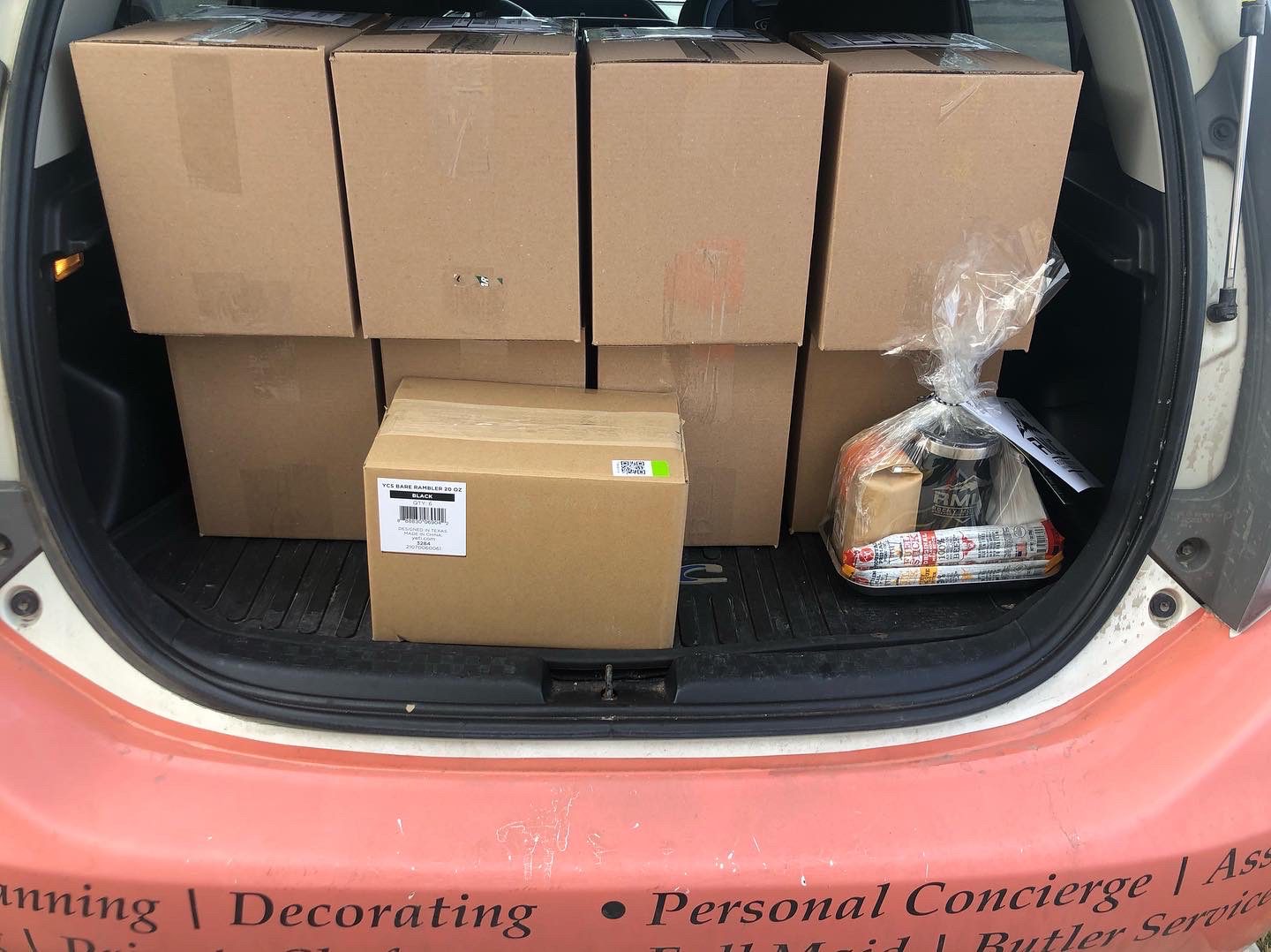 A trunk with boxes and a box of cake in it.