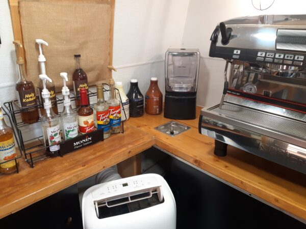 A counter with many bottles and toasters on it