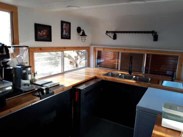 A kitchen with wooden counters and black cabinets.