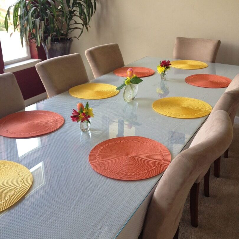 A table with eight chairs and six placemats.